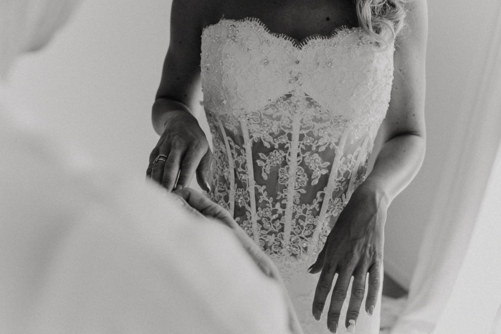 Femme en train de mettre ses gants en dentelle de mariée