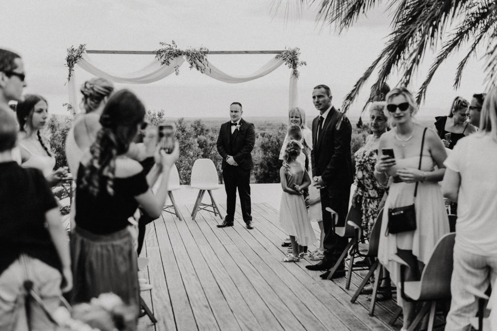 Homme devant l'autel et invités attendant la mariée