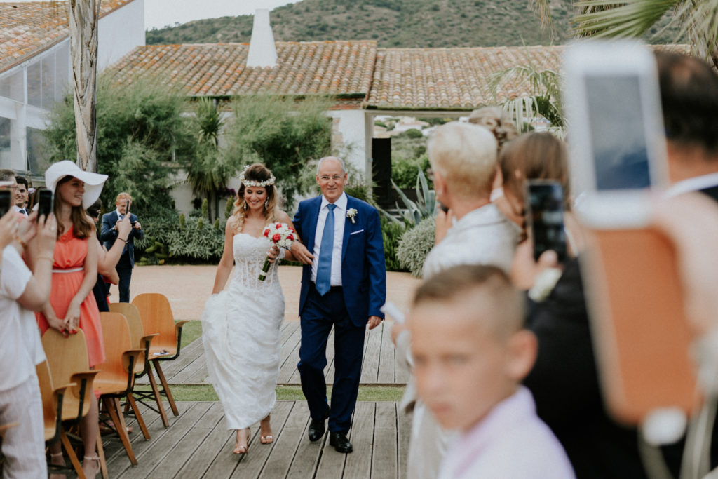 Mariée marchant dans l'allée au bras de son papa