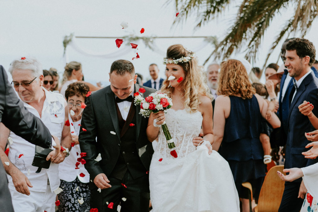 Jeunes mariés recevant des pétales de fleurs