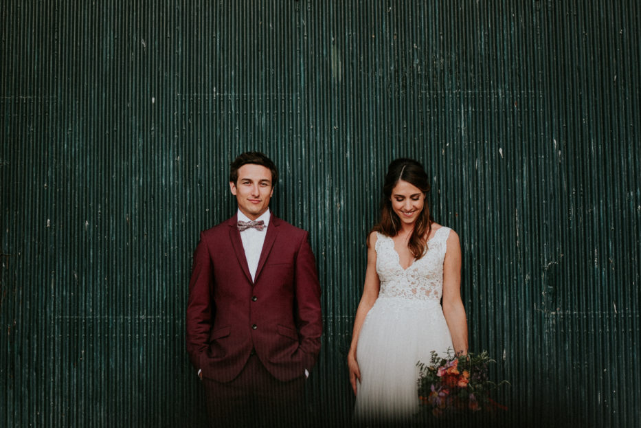 Photographe mariage béziers - jeunes mariés devant une porte de grange verte au Domaine de l'Ale à Capestang
