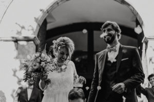 Jeunes mariés sortant de l'église avec pétales de fleurs qui volent