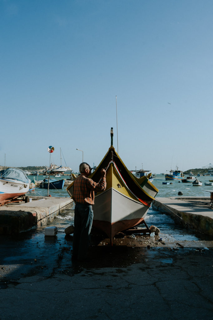Homme nettoyant son bateau - Cyrielle Riba Photographe - Voyage Malte